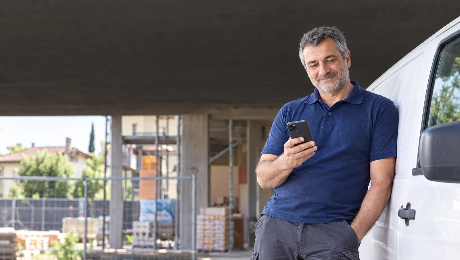 Il titolare appoggiato al furgone rilegge una bozza sul telefono